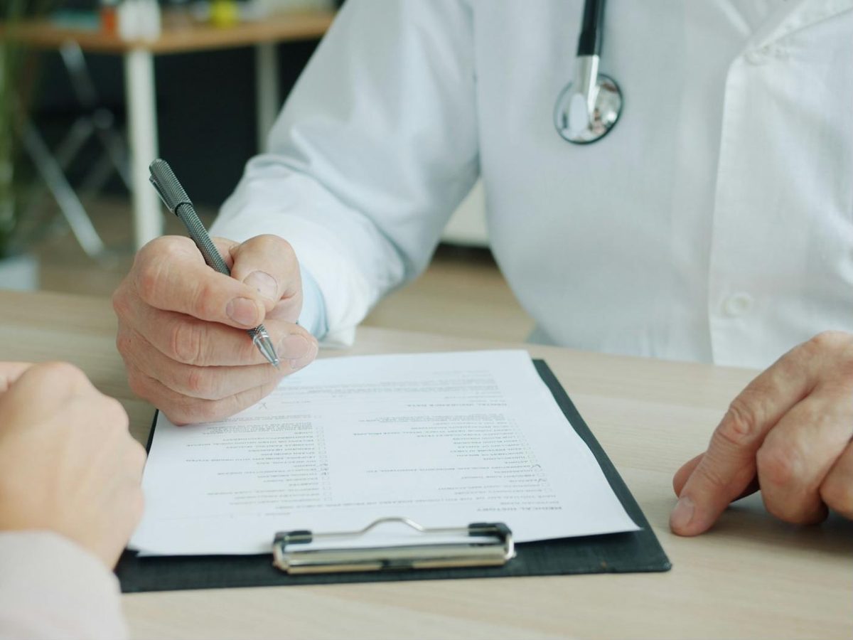 Médico firmando un certificado médico